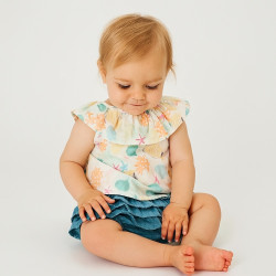 Conjunto de blusa con estampado oceánico y gran volante en el cuello. Bloomer azul tejano con tres volantes.